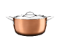 Copper pot with a glass lid and metal handles on a black background.