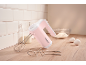 Pink hand mixer with attachments, milk, flour, and eggs on a wooden countertop.