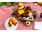 Picnic spread with cheese, berries, crackers, chocolate, jam, and croissants.