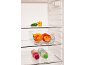 Open fridge with apples, banana, peppers, and two bottles of drinks on shelves.