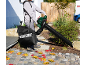 Man using a leaf blower with a collection bag, clearing fallen leaves.