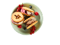 Ice cream sandwiches with cookies and berries on a green plate.