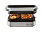 Open electric grill with two grilled cheese and vegetable sandwiches.