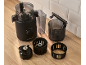 Black food processor with accessories on a wooden table.