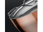 Close-up of a shiny copper pot with a stainless steel lid and handle.
