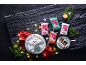 Christmas cake decorated with white and red icing, colorful fondant packages, and a slice of chocolate cake, with festive decoration.