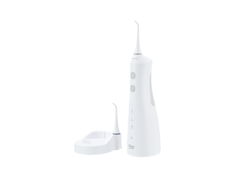 White oral irrigator with a nozzle and a charging station.