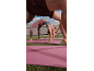 People doing yoga on pink mats outdoors, viewed from a low angle.