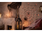 Halloween decorations: glowing spiderweb with spider, candles, and cobwebs in a room.