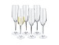 Six champagne flutes, one filled with sparkling wine, on a black background.