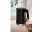 Black honeycomb textured kettle in a kitchen with a bowl of muffins.