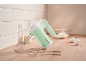 Hand mixer with whisks and dough hooks, next to flour, milk, and eggs.
