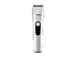 Silver hair clipper with a black power button on a black background.