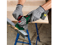 Man in gloves cuts metal beam with angle grinder, sparks flying.