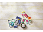 Colorful fondant packages and decorated pastries on a white wooden table.