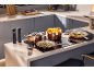 Copper pots and pans on an induction hob, with food and kitchen accessories.
