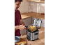 Man preparing french fries with a kitchen deep fryer.