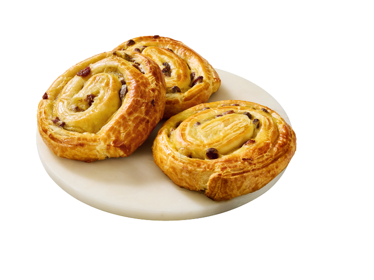 Three golden-brown raisin swirls on a white marble plate