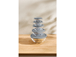 Stack of five clear glass bowls with grey lids on a wooden surface.