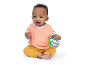 Happy baby in a peach top and mustard pants, holding a colorful toy ball.