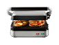 Open electric grill with two grilled cheese and vegetable sandwiches.