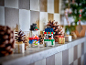 Two festive toy snowmen made of building blocks on a decorated mantelpiece.