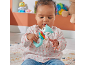 Baby sitting on a rug, playing with a blue fox-shaped rattle and colorful rings.