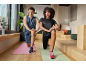 Man and woman in sportswear doing lunges on yoga mats.