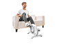 Man sitting on a sofa using a mini exercise bike for legs.