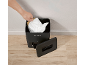 A hand places a paper filter and a white bag into a black paper shredder with an open lid.
