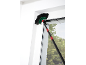 Cobweb duster with telescopic handle cleaning a window corner.