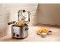 Deep fryer with french fries and sauces on a wooden countertop.