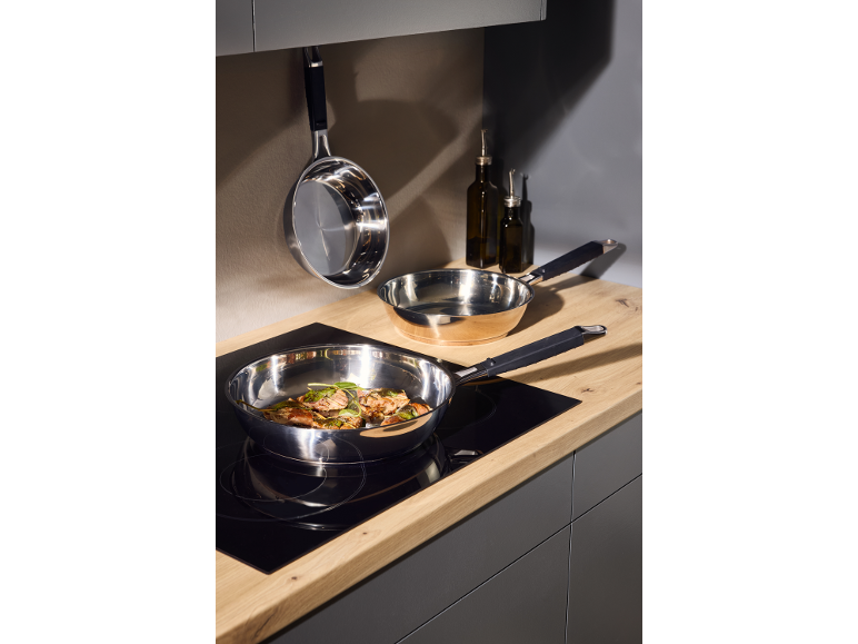 Pans with food on the hob and hanging in the kitchen.