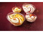 Four desserts: two creamy desserts with a Deluxe label, one with caramel sauce and one with strawberry sauce, and two bowls of ice cream.