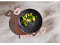 Frying pan with vegetables on a gray background with a pink napkin
