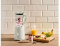 Blender with berries, yogurt, bananas, and orange juice in a kitchen.