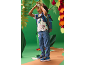 Boy in cartoon character t-shirt, jeans, and blue sneakers, looking through toy binoculars.