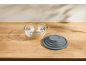 Set of glass mixing bowls with gray silicone lids on a wooden table.