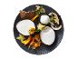 Coconut dessert with fresh fruit and toasted coconut flakes on a dark plate.