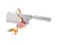 Butcher knife with lamb chops, tomato, garlic, and herbs.