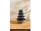 Set of five glass food storage bowls with black lids, stacked on a wooden table.