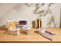 Transparent food containers with pasta, beans, and cereals on a wooden table.