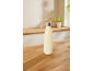 Cream insulated bottle on a wooden kitchen counter with blurred background