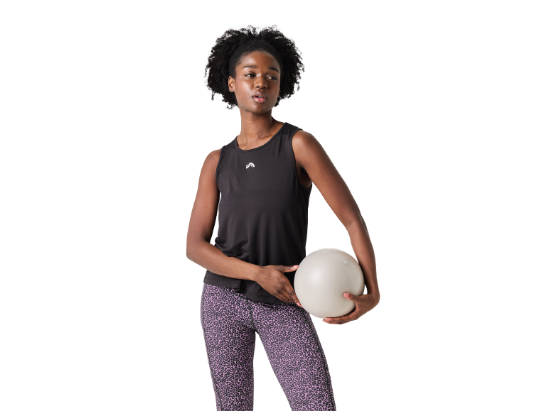 Woman in black tank top and purple leopard leggings, holding a fitness ball.