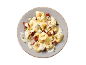 Tortellini with cheese sauce, sun-dried tomatoes, and herbs on a plate.