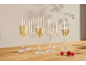 Champagne flutes with sparkling wine and raspberries on a wooden table.