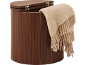 Brown wooden laundry hamper with hinged lid and beige throw blanket.