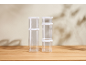 Clear food storage containers with white lids, stacked on a wooden surface.