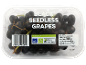 Black seedless grapes in a clear plastic container with product information.