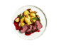 Roast beef with potatoes, mushrooms, and berry sauce on a white plate.